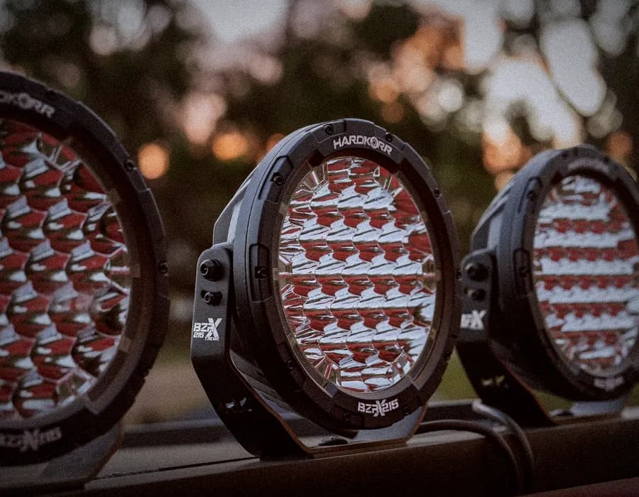 Three Hardkorr BZX round LED driving lights in a row at dusk