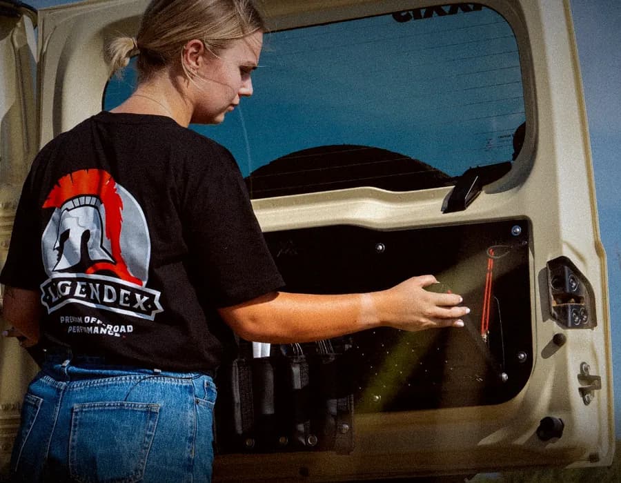 Gear being clipped onto a Rogue MOLLE panel on the inside of a 4WD's rear door