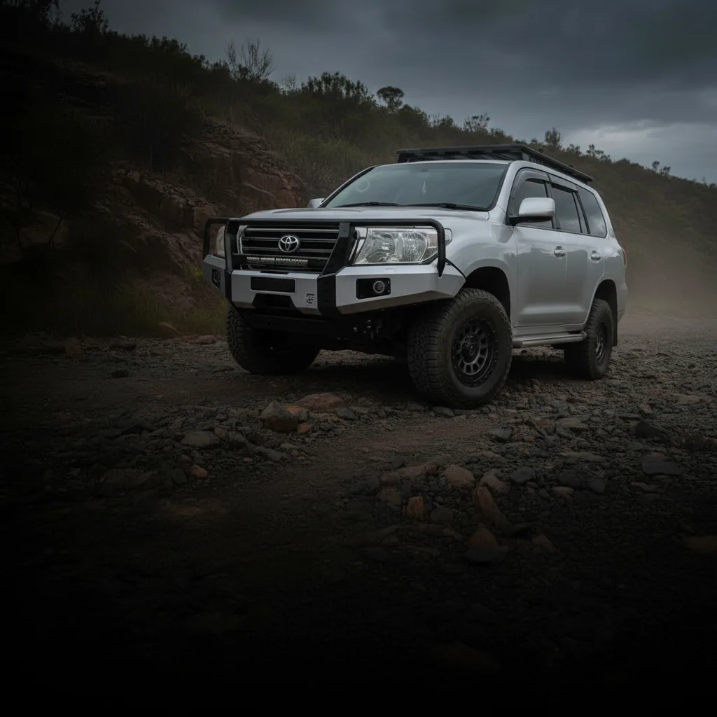 A 4WD with a steel bull bar and rock sliders on a rocky Queensland track at dusk