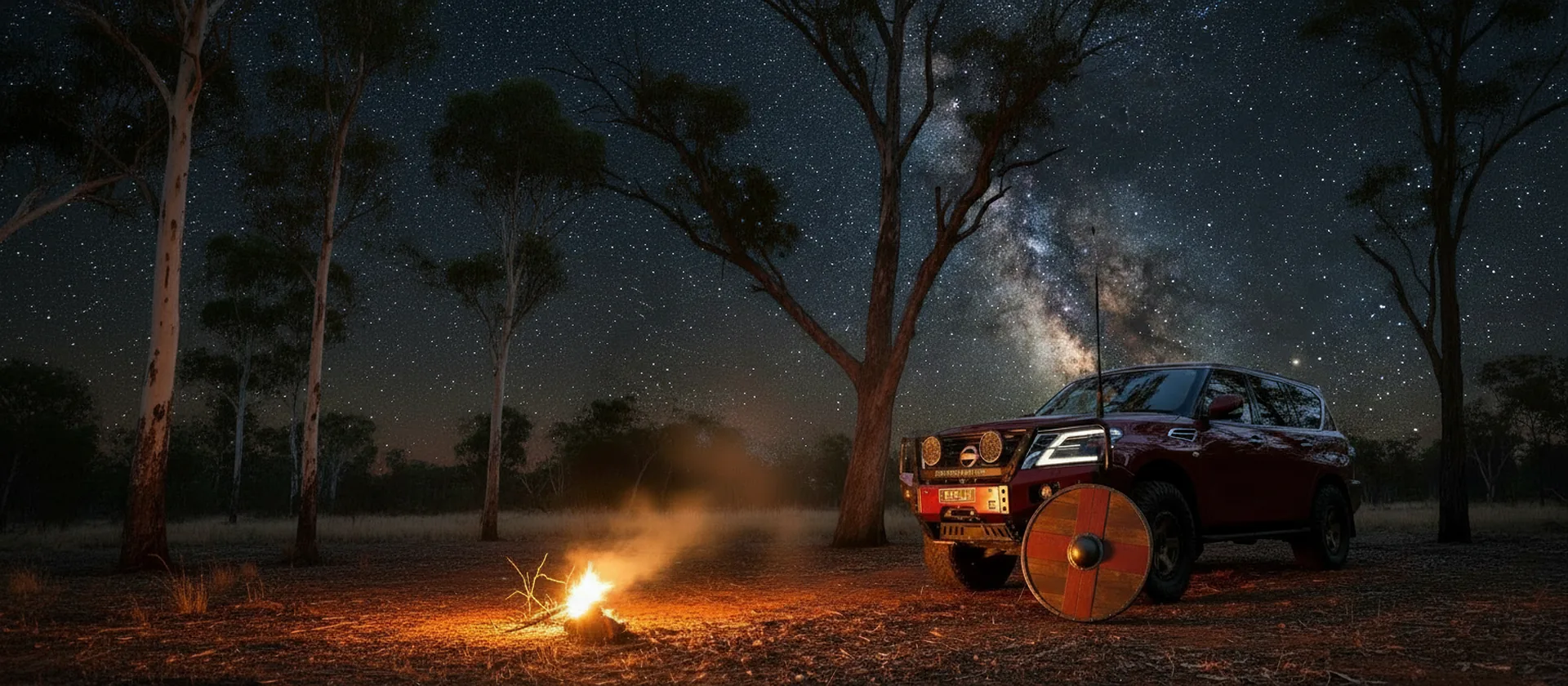 Red Nissan Patrol Y62 with a Raslarr hooped bull bar at a night camp, a round shield leaning on the front wheel